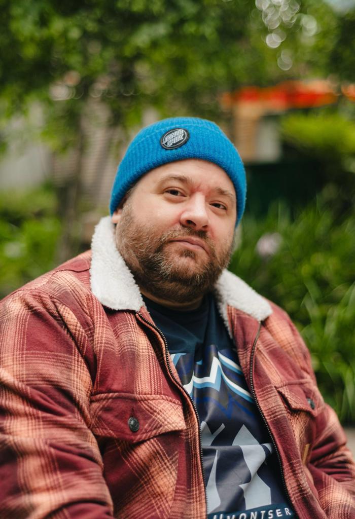 Disabled Speaker Scott Whitney wearing a blue beanie hat and coat over his t shirt