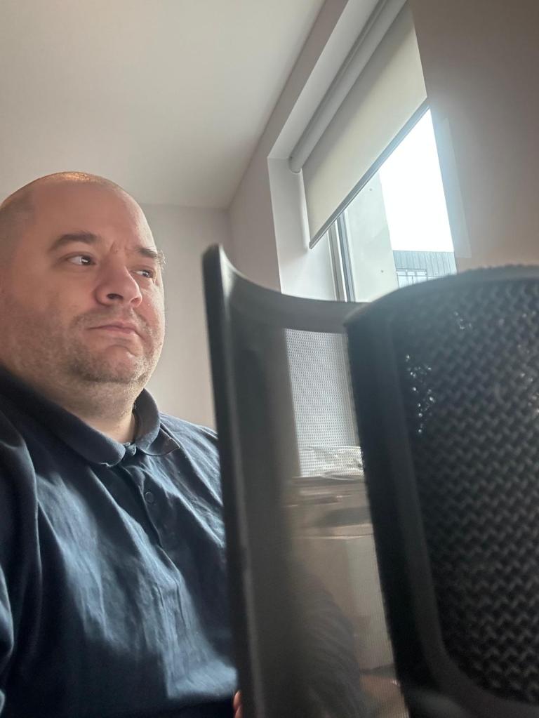 Scott Whitney, behind the microphone ready to speak about disability, inclusion and accessibility to a local authority